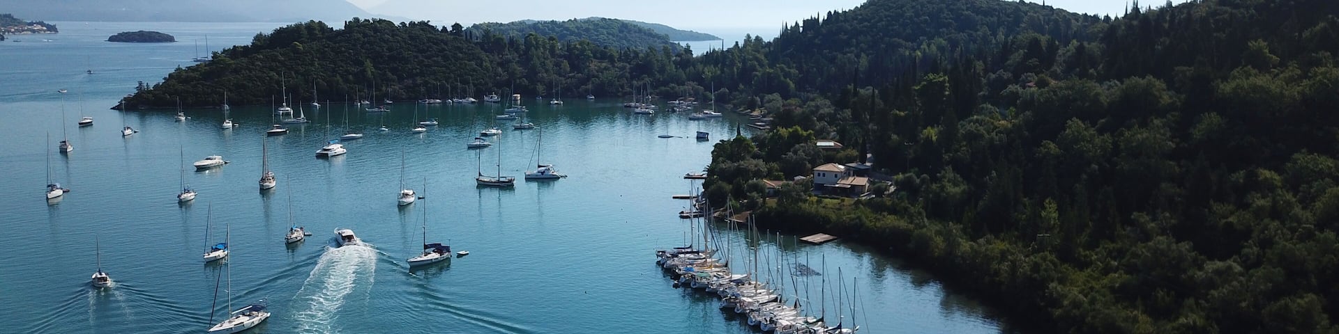 Aerial drone bird's eye view photo of iconic port of Nidri or Nydri a safe harbor for sail boats and famous for trips to Meganisi, Skorpios and other Ionian islands, Leflkada island, Ionian, Greece