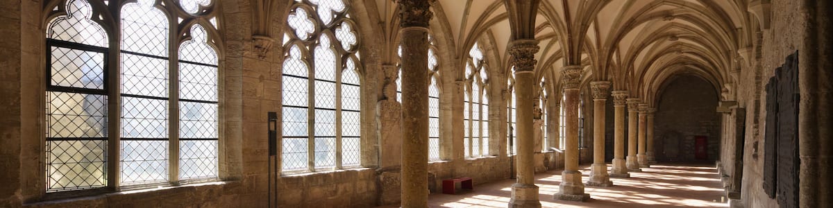 A cathedral interior with arched windows and columns.