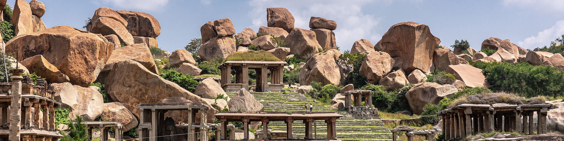 Ruinas antiguas con grandes formaciones rocosas y estructuras de piedra.