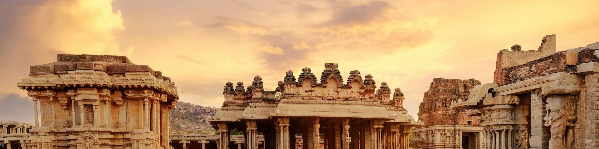 Ancient stone chariot with archaeological ruins in the courtyard of Vittala Temple at Hampi, Karnataka India at sunset