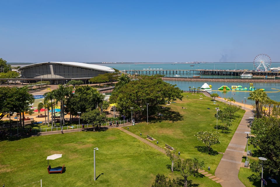 A coastal park with a Ferris wheel, a pier, and a stadium.