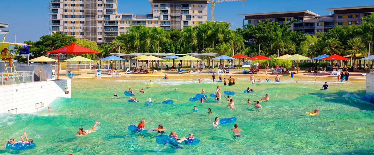 A water park with clear blue water, inflatable tubes, and umbrellas.