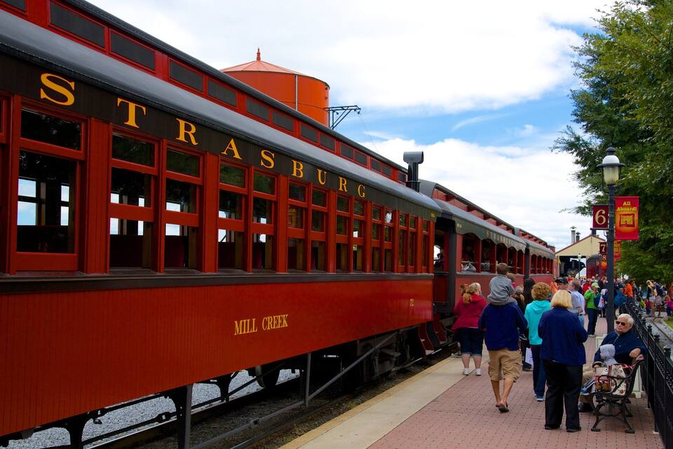 A red train with 'Strasburg' and 'Mill Creek' written on it.