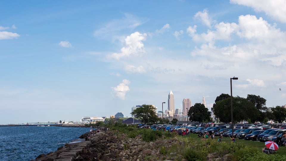 Lake Erie, Cleveland, Ohio/ USA - 3 September 2018: People relax on the beach, tall skyscrapers are visible in the distance. Cleveland skyline