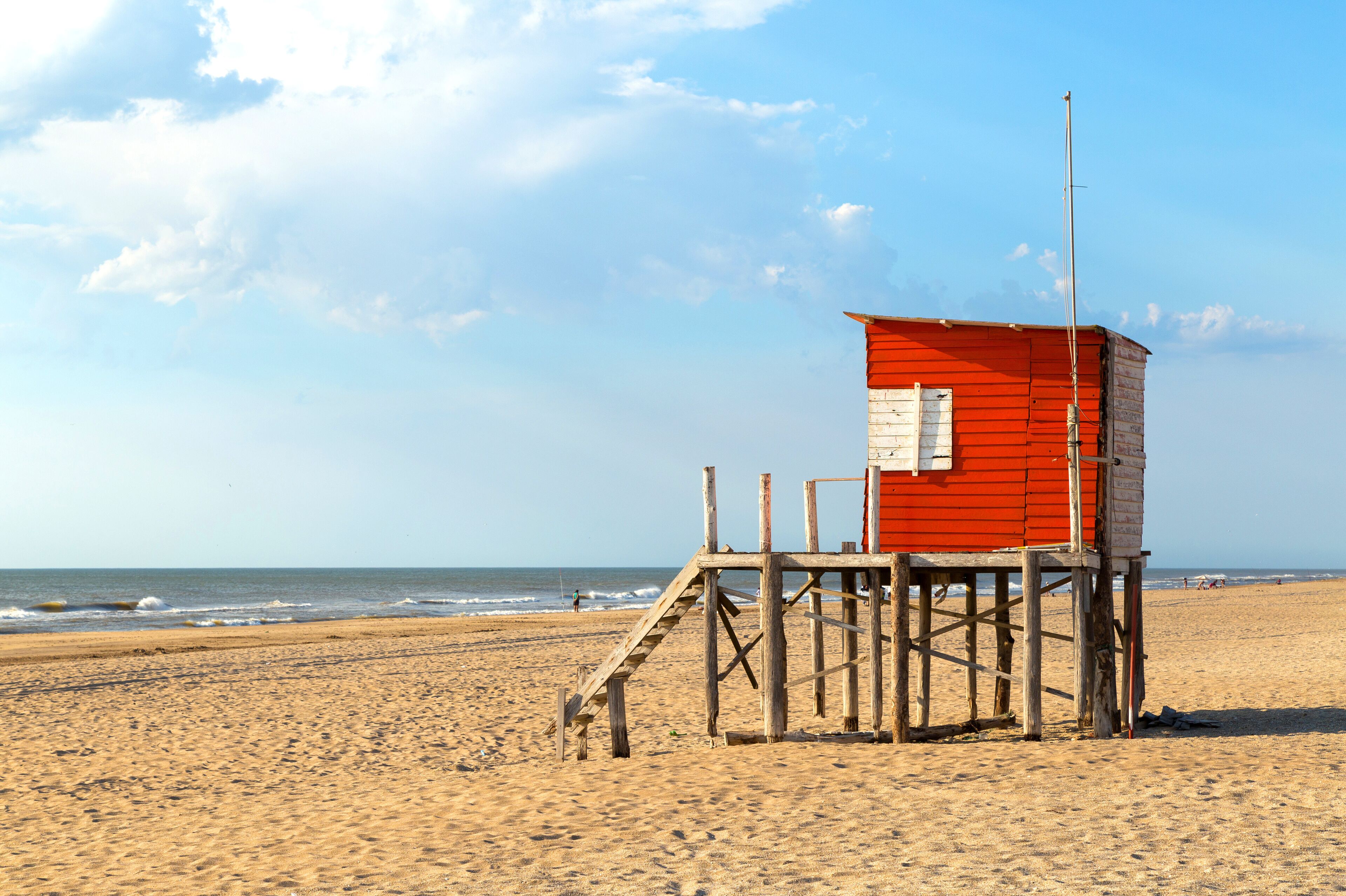 Beach scene. Red lifeguard tower in foreground. Beautiful morning of summer. The sun bright over the sea.
