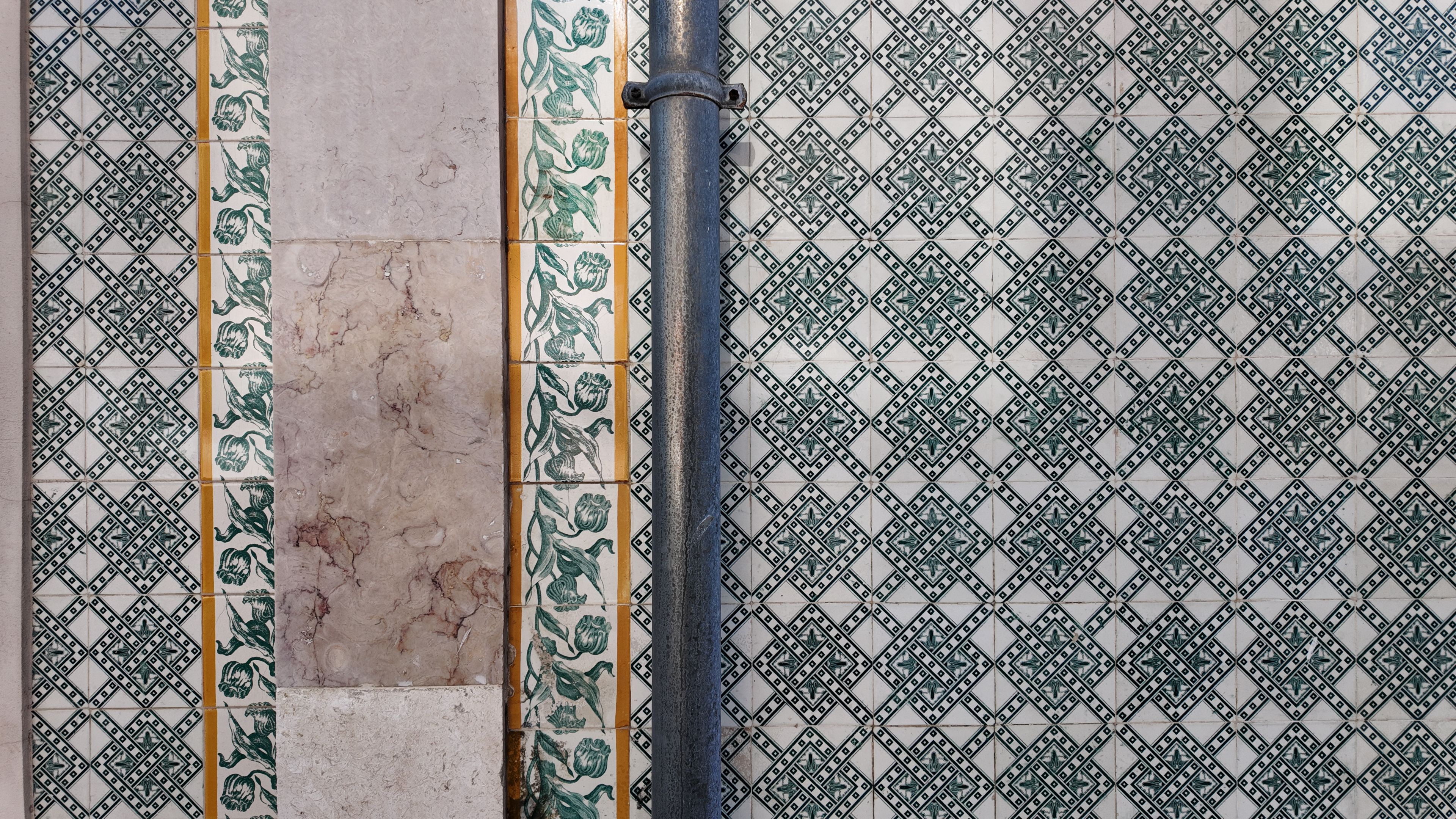 Traditional Portuguese azulejo ceramic tile wall with decorative geometric ornament and natural stone architectural detail on a historic building in Trafaria Portugal