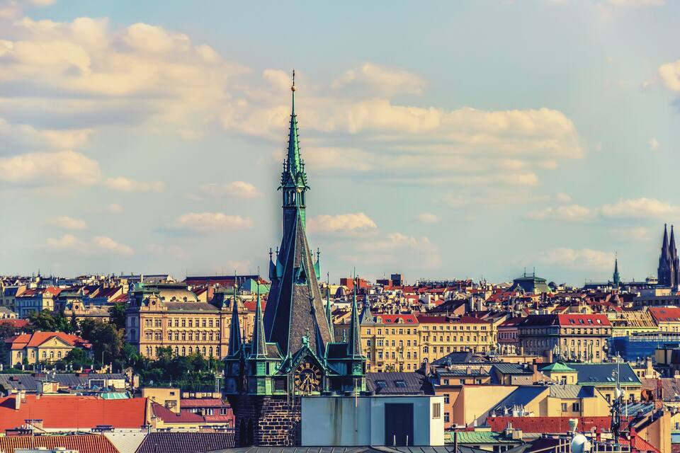 Paisagem urbana com uma torre de igreja imponente e edifícios ao redor.