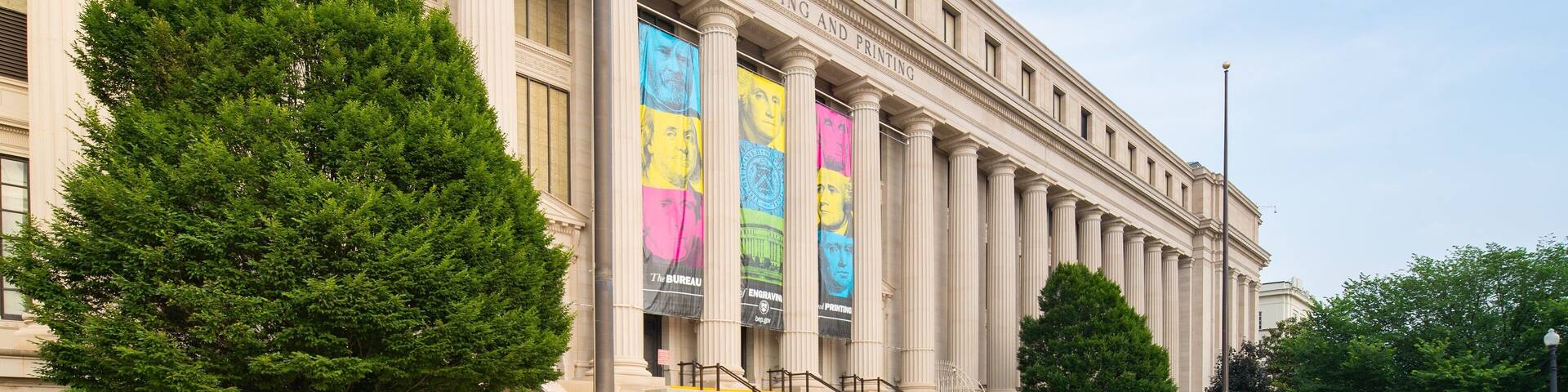 A large building with columns and banners.