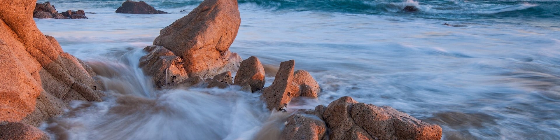 A rocky shoreline with waves crashing against the rocks.