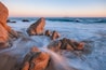 A rocky shoreline with waves crashing against the rocks.