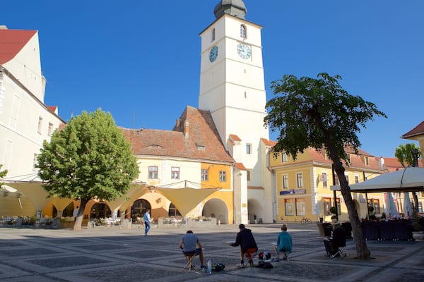 Ein historischer Platz mit einem markanten Glockenturm, Kopfsteinpflaster und traditionellen Gebäuden.