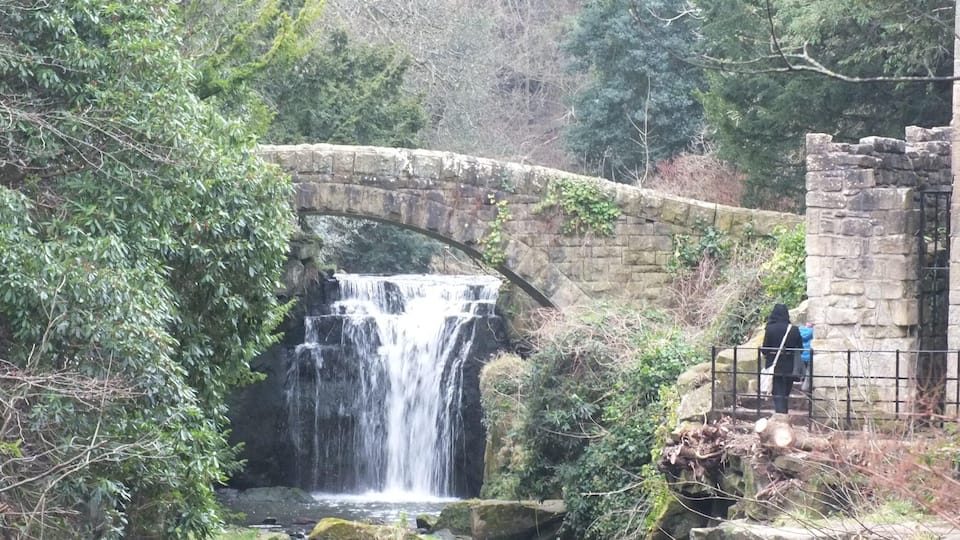 Jesmond Dene is one of the Ouseburn Parks, near Jesmond in Newcastle upon Tyne. The Land was given to William Armstrong as a wedding present in 1835. He planted hundreds of shrubs and laid miles of paths, built a grotto, many bridges and a waterfall on the Ouse Burn. Today it is a public park. It was refurbished with a Heritage Lottery. Grant. Mabel's Mill (the Old Mill) (Heaton Mill) is a feature. In its time the mill has ground corn, pig feed and flint for the potteries. This flint version overshot mill dates from the 1789, and upstream is an artificially built waterfall.