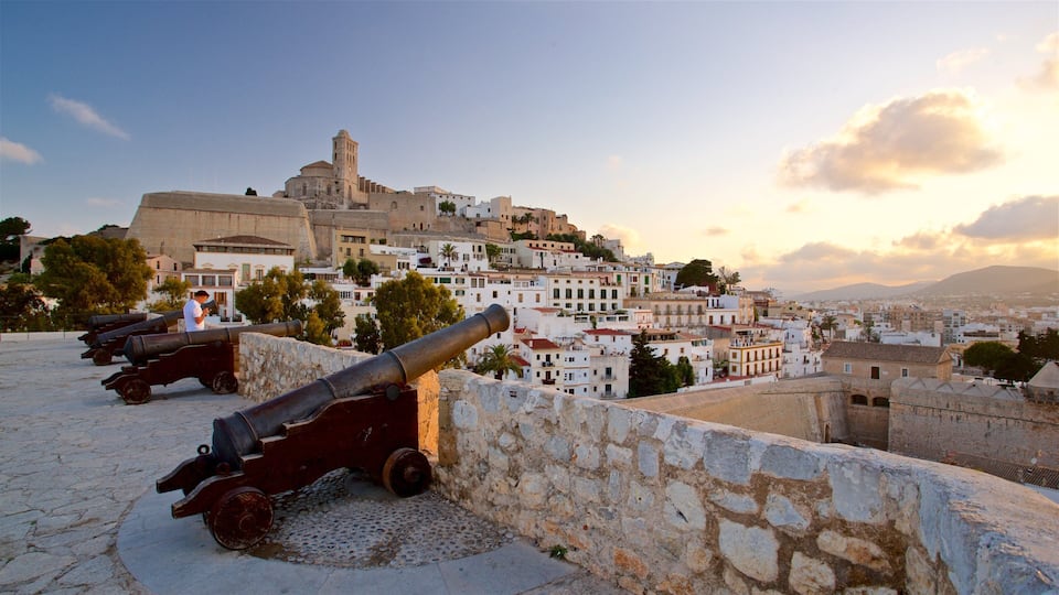 Dalt Vila showing military items, a sunset and a city