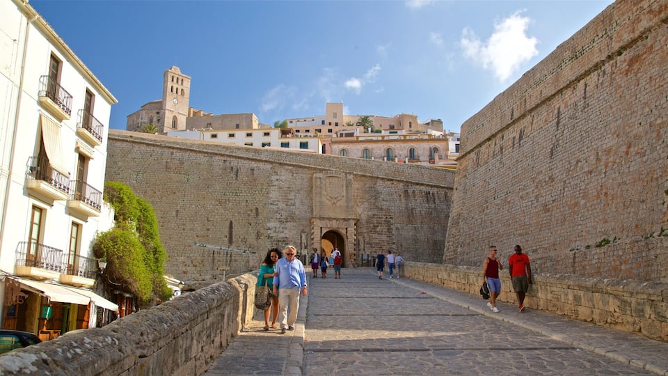 A stone pathway leading to a historic gate with a tower in the background.