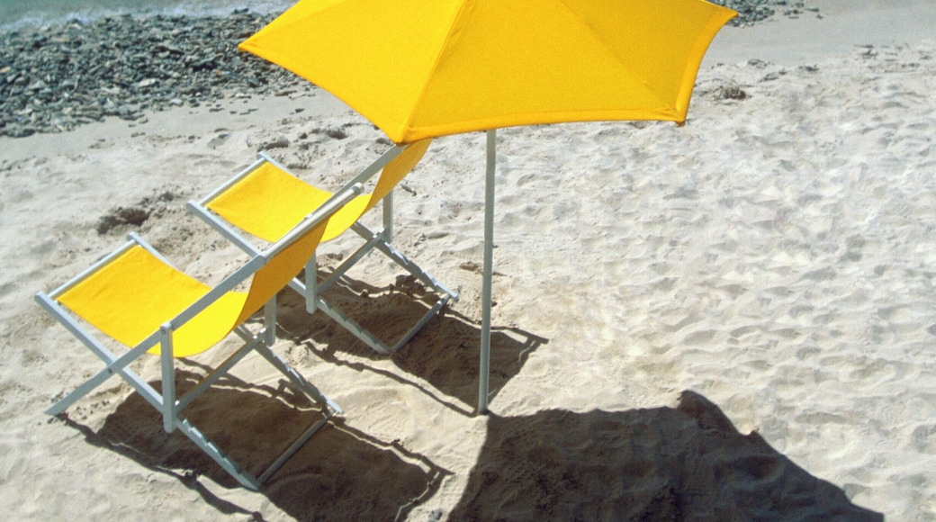 Yellow umbrella and two lounge chairs on the beach at Kalki, Curacao, Caribbean