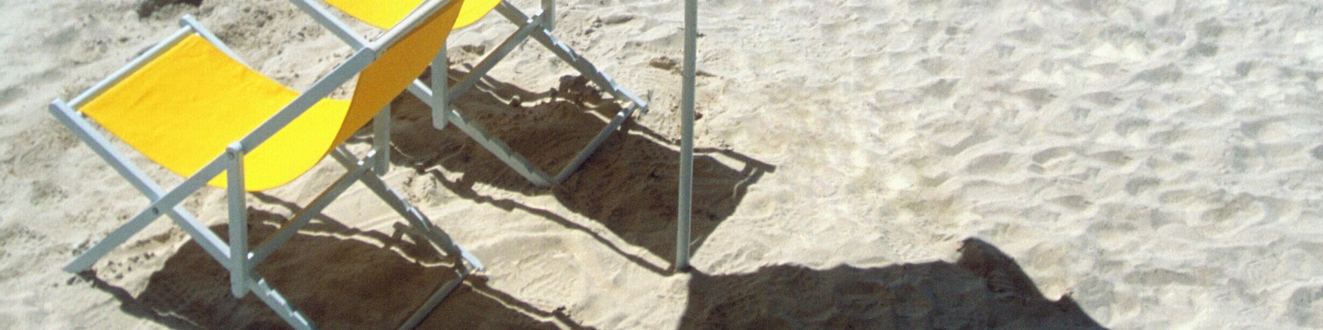 Yellow umbrella and two lounge chairs on the beach at Kalki, Curacao, Caribbean