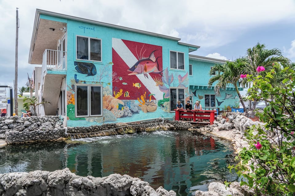 Un edificio con un mural de un pez y un arrecife de coral.