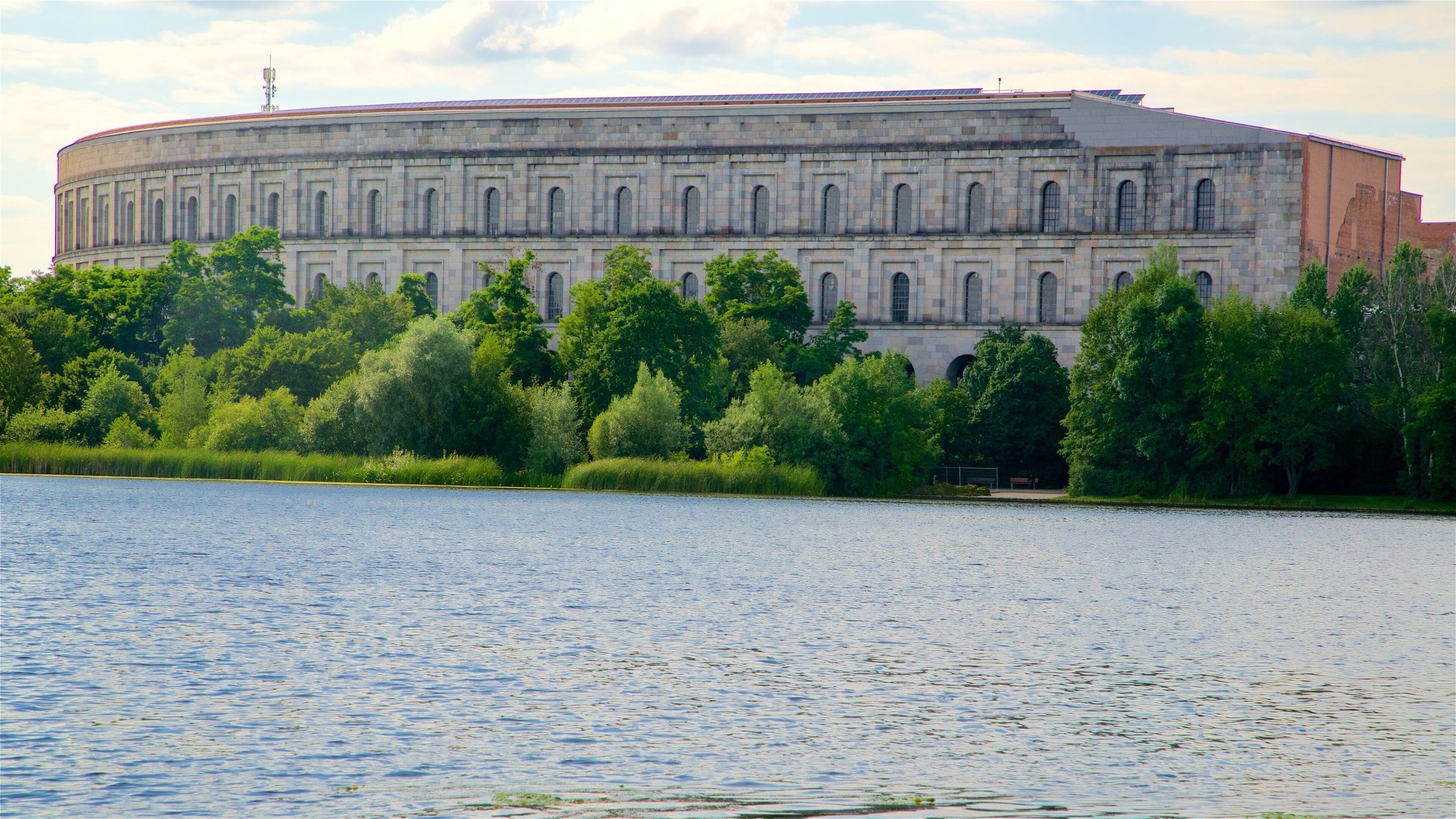Reichsparteitagsgebaude which includes a lake or waterhole, a sunset and heritage architecture