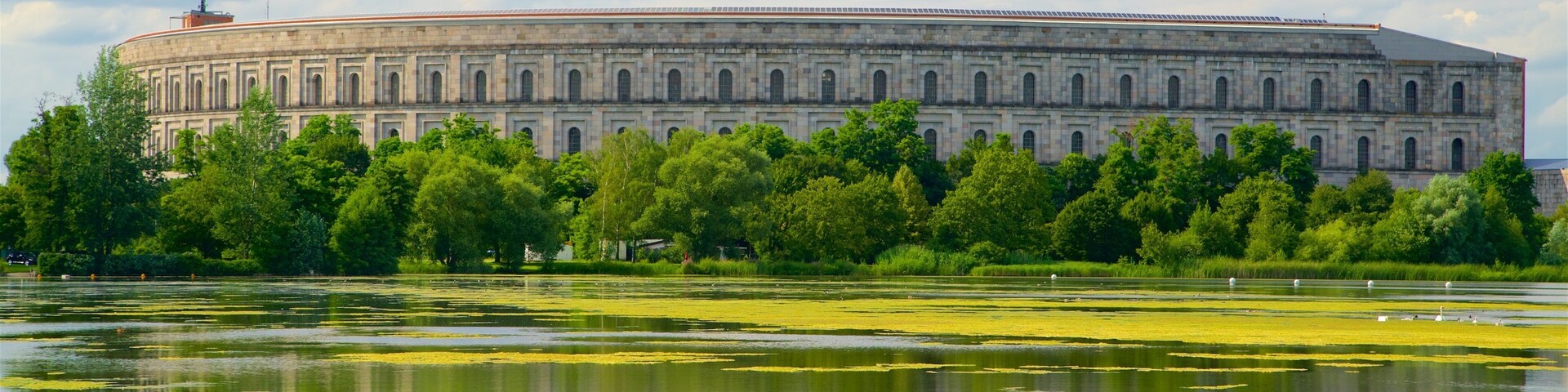 Reichsparteitagsgebäude ofreciendo un lago o laguna, un atardecer y arquitectura patrimonial