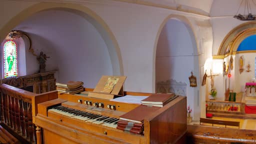 An organ with sheet music, a stained glass window, and a church interior with arched ceilings and religious statues.