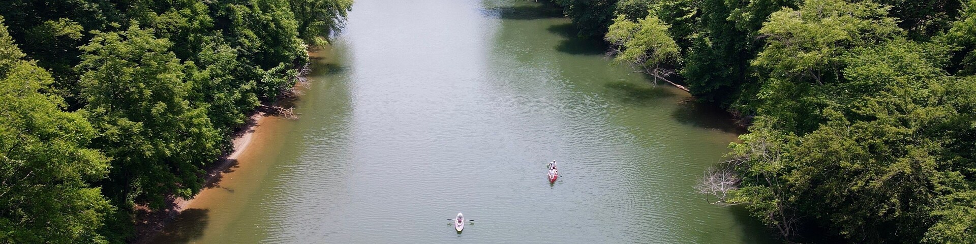 Areal view of two kayaks paddling down the Etowah River lined by trees in Northern Georgia