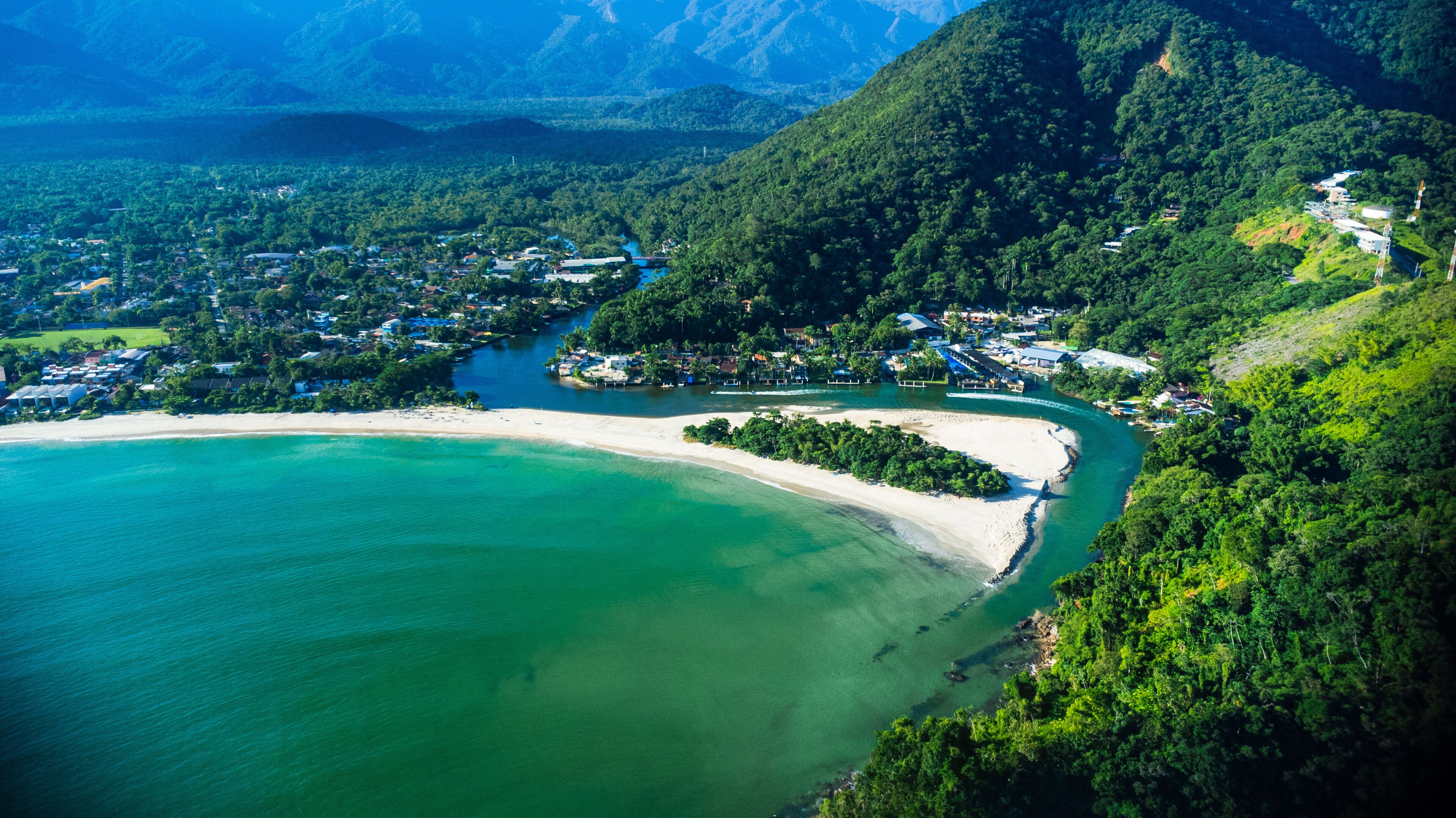 Aerial view of a tropical white sand beach meeting a green river estuary / Vista aerea do encontro do Rio Una com o mar São Sebastião
