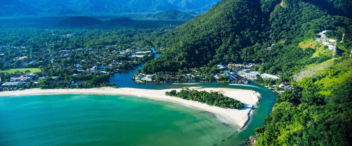 Aerial view of a tropical white sand beach meeting a green river estuary / Vista aerea do encontro do Rio Una com o mar São Sebastião