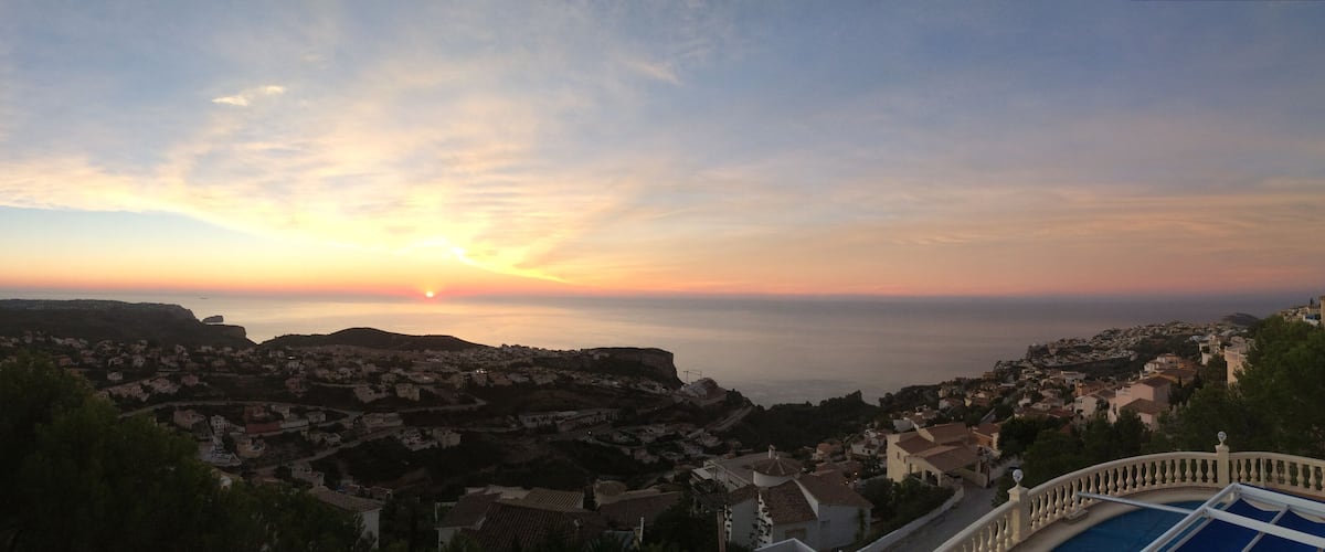 A coastal town at sunset with a clear sky and a view of the sea.