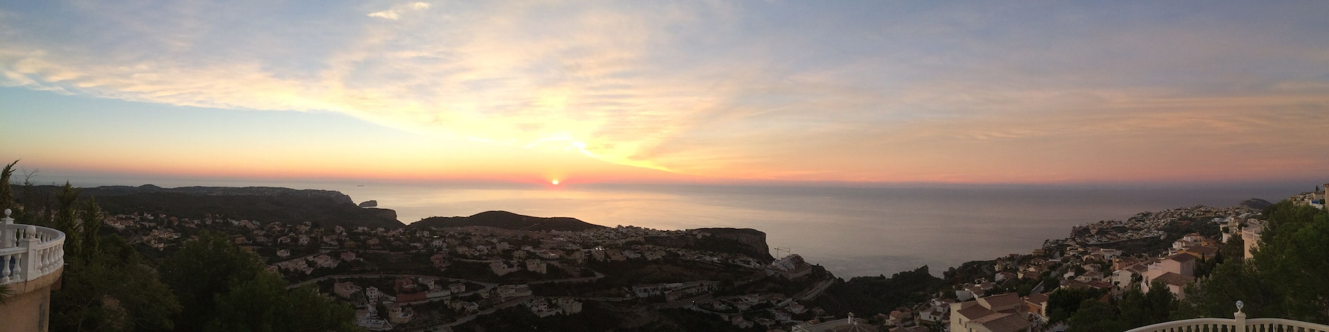 A coastal town at sunset with a clear sky and a view of the sea.