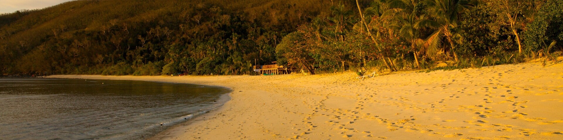 Discover the serene beauty of Naviti Island in Fiji at sunset with golden sands and lush landscapes