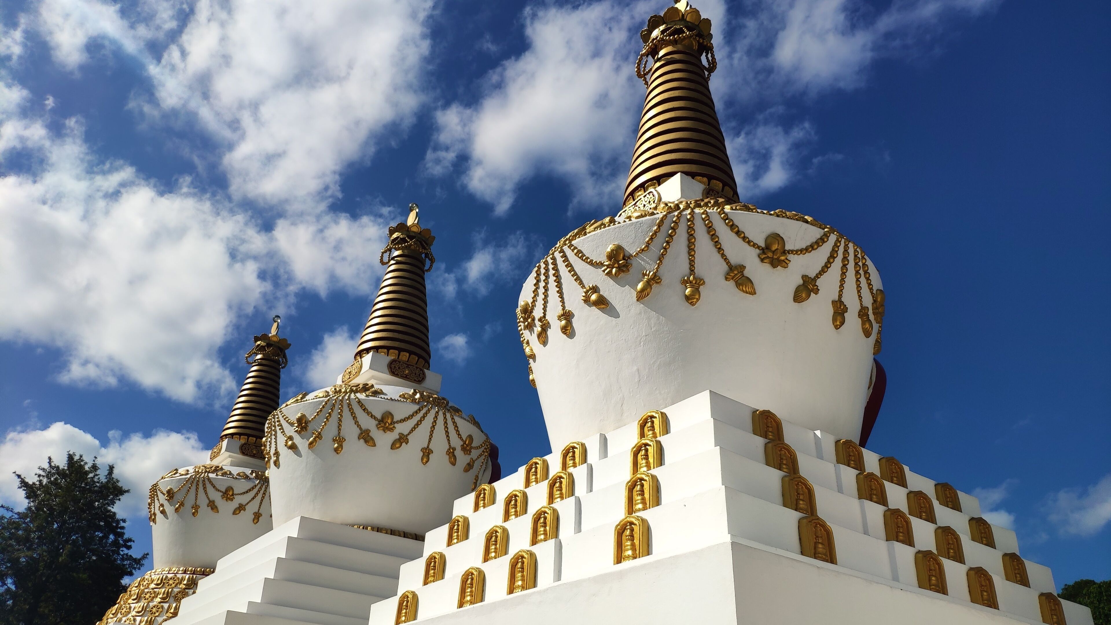 White stupas with blue sky in background at Buddhist temple Chagdud Gonpa Khadro Ling.  Tres Coroas, Rio Grande do Sul, Brazil. 