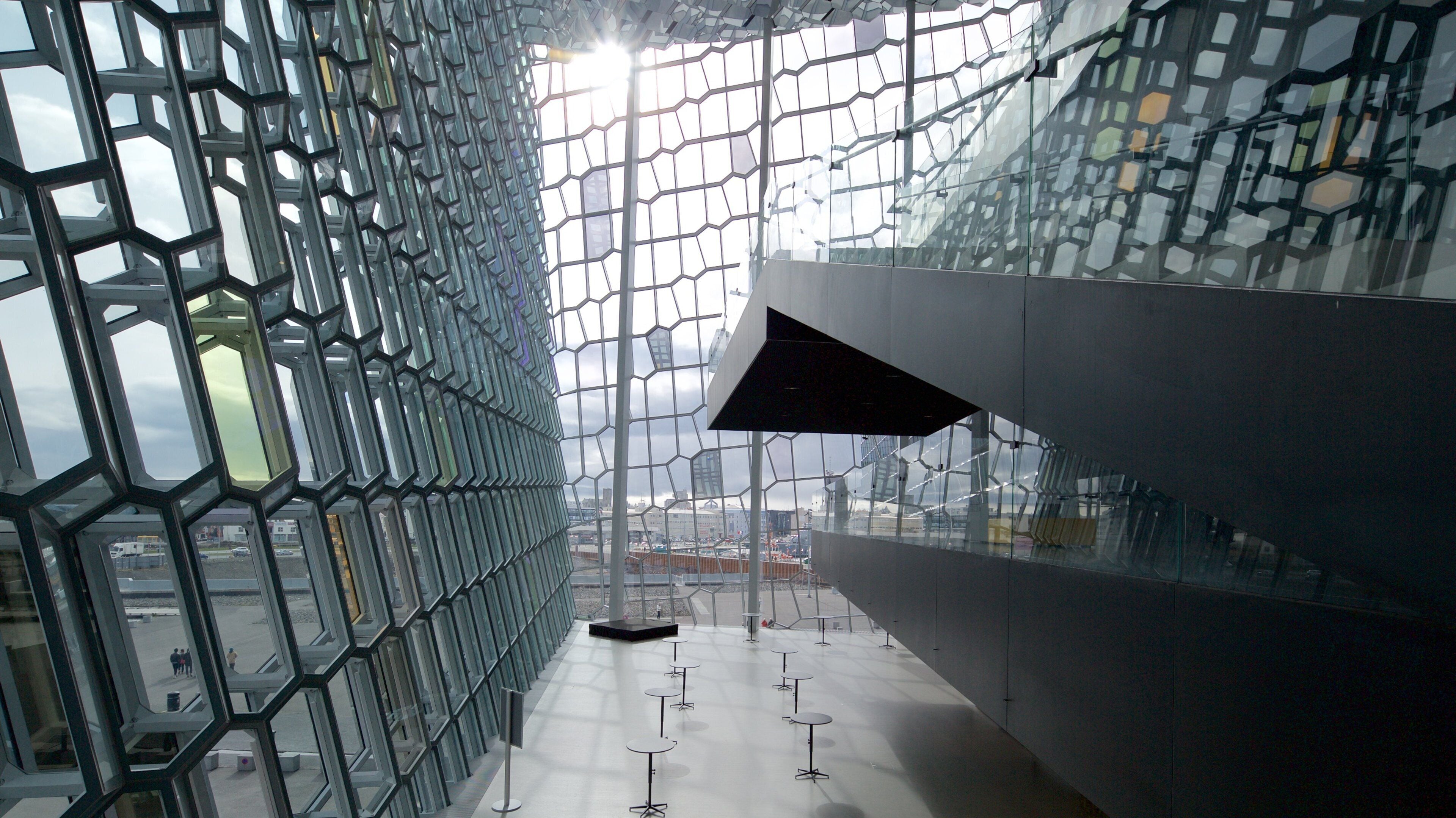 A modern architectural structure with a geometric glass facade and a concrete interior.