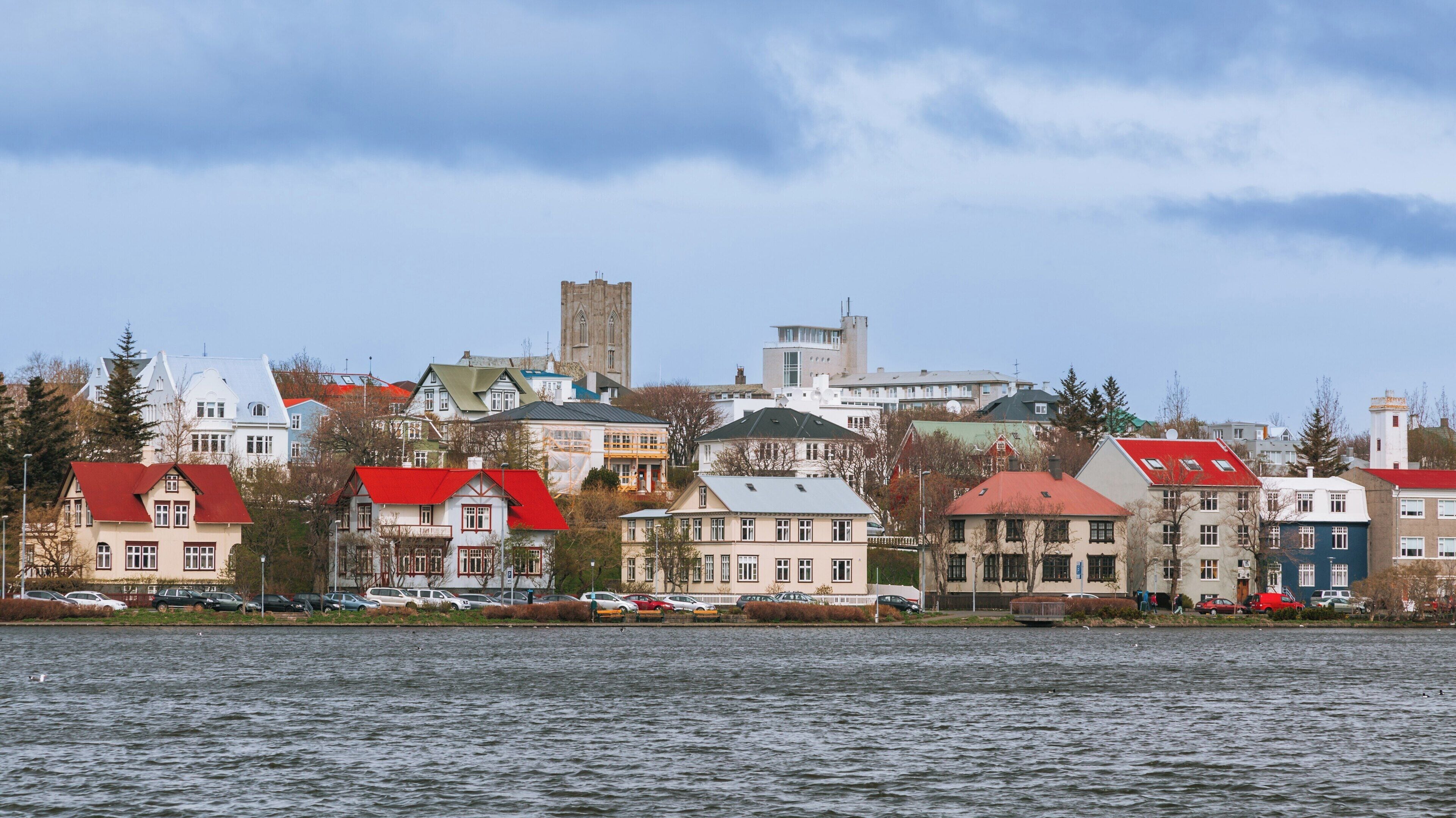 Colorful buildings line the waterfront near Harpa, showcasing the charm of Reykjavik in the Capital Region of Iceland on a clear day