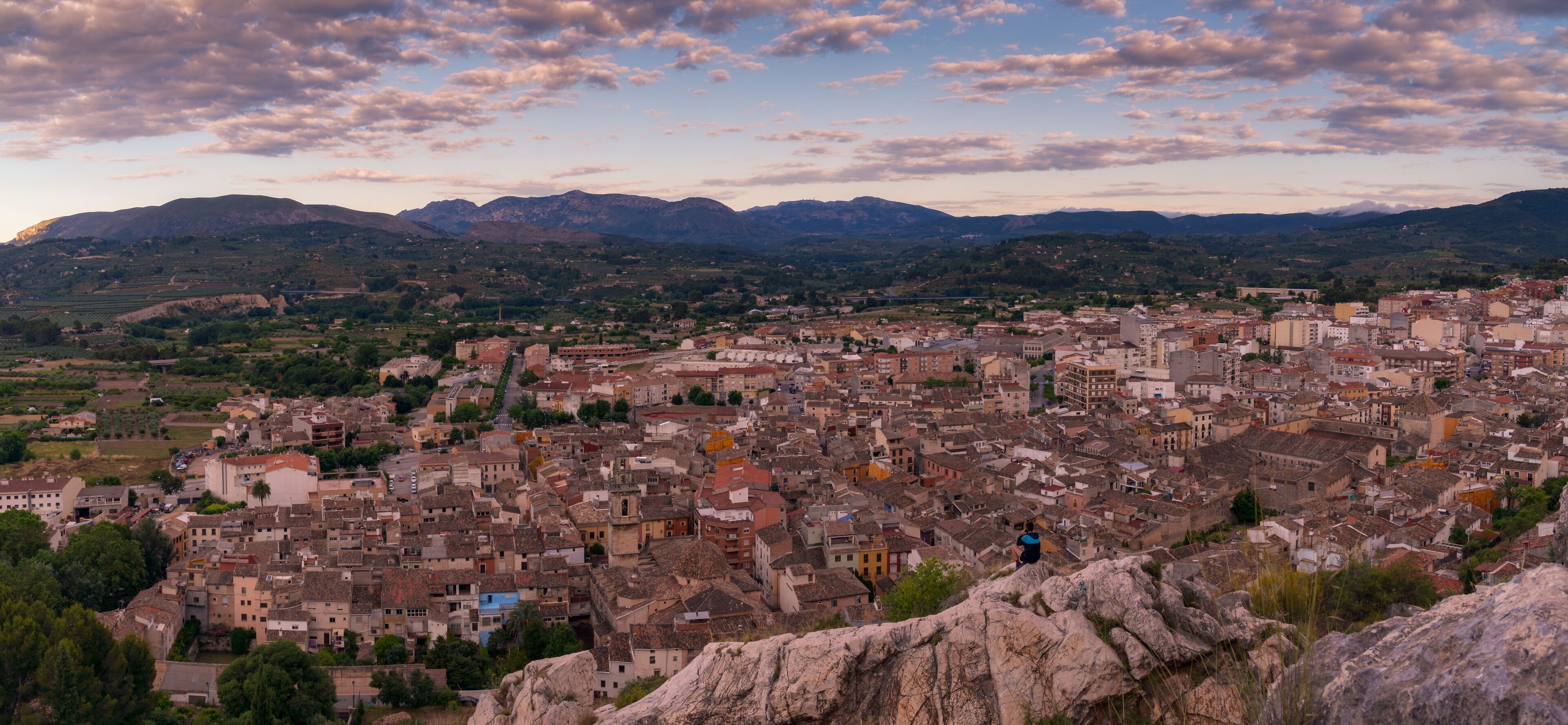 A panoramic view of a historic town with a mountainous backdrop.