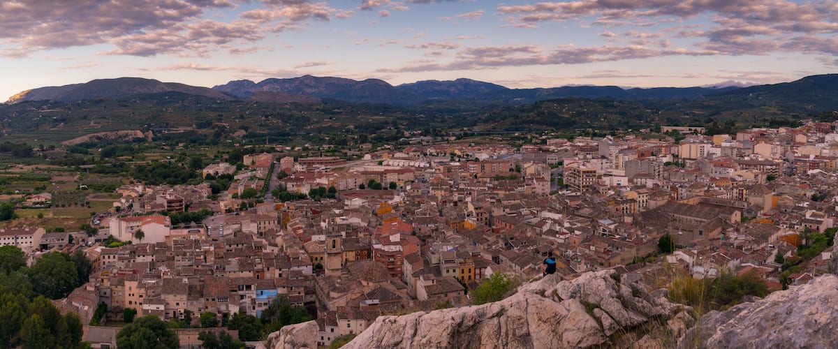 A panoramic view of a historic town with a mountainous backdrop.