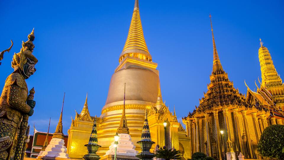 A large golden stupa surrounded by smaller structures and statues.