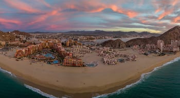 Un paysage urbain côtier avec une plage, des hôtels et des montagnes.