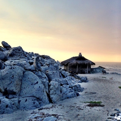 The stone sleeping cabin. Spectacular place to cozy up for a night on the beach. Complete with wood for bonfire, solar power, stove for AM coffee, and waves crashing at your door. A most hidden gem, off the grid. About $150/night.