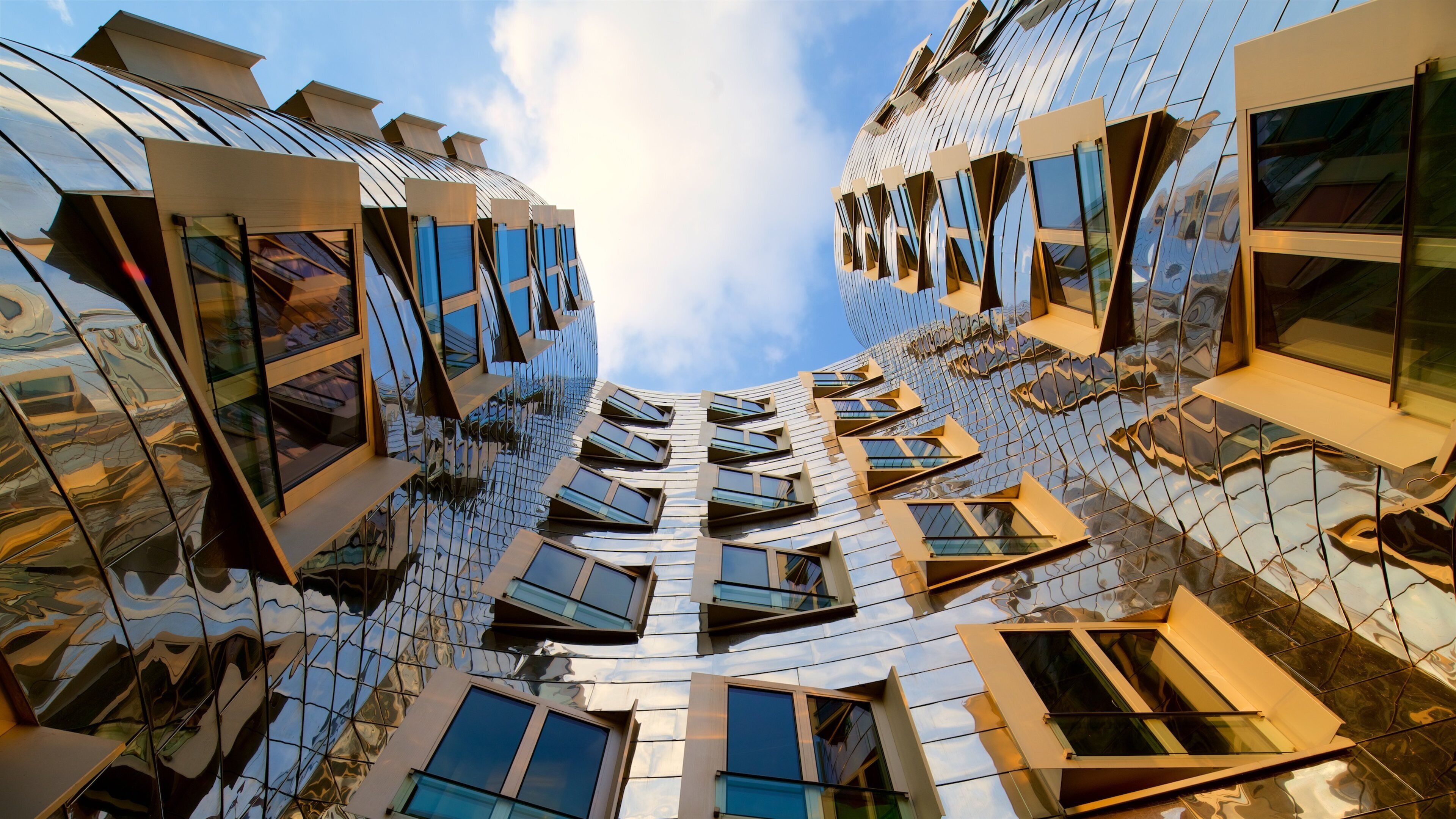 A modern architectural building with a reflective glass facade and multiple windows.