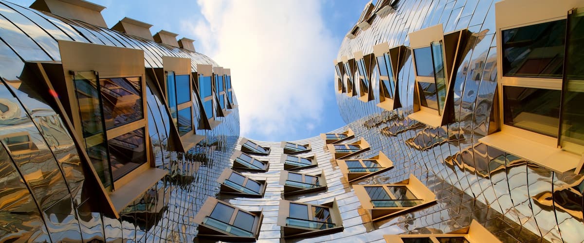 A modern architectural building with a reflective glass facade and multiple windows.