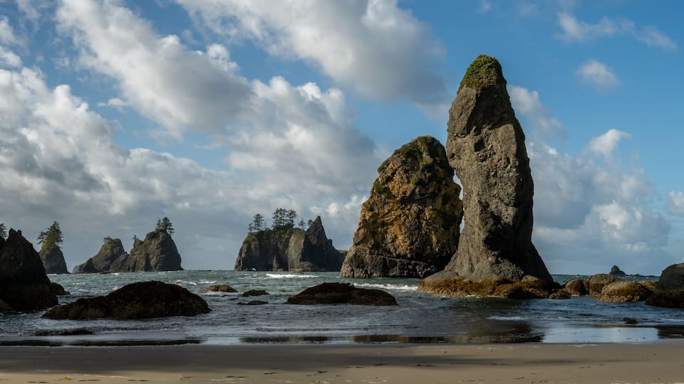 A rocky coastline with prominent rock formations and a clear sky.