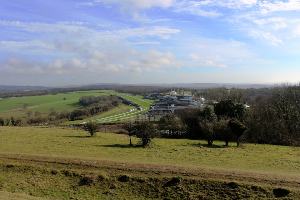 A rural landscape with a bridge, green fields, and trees.