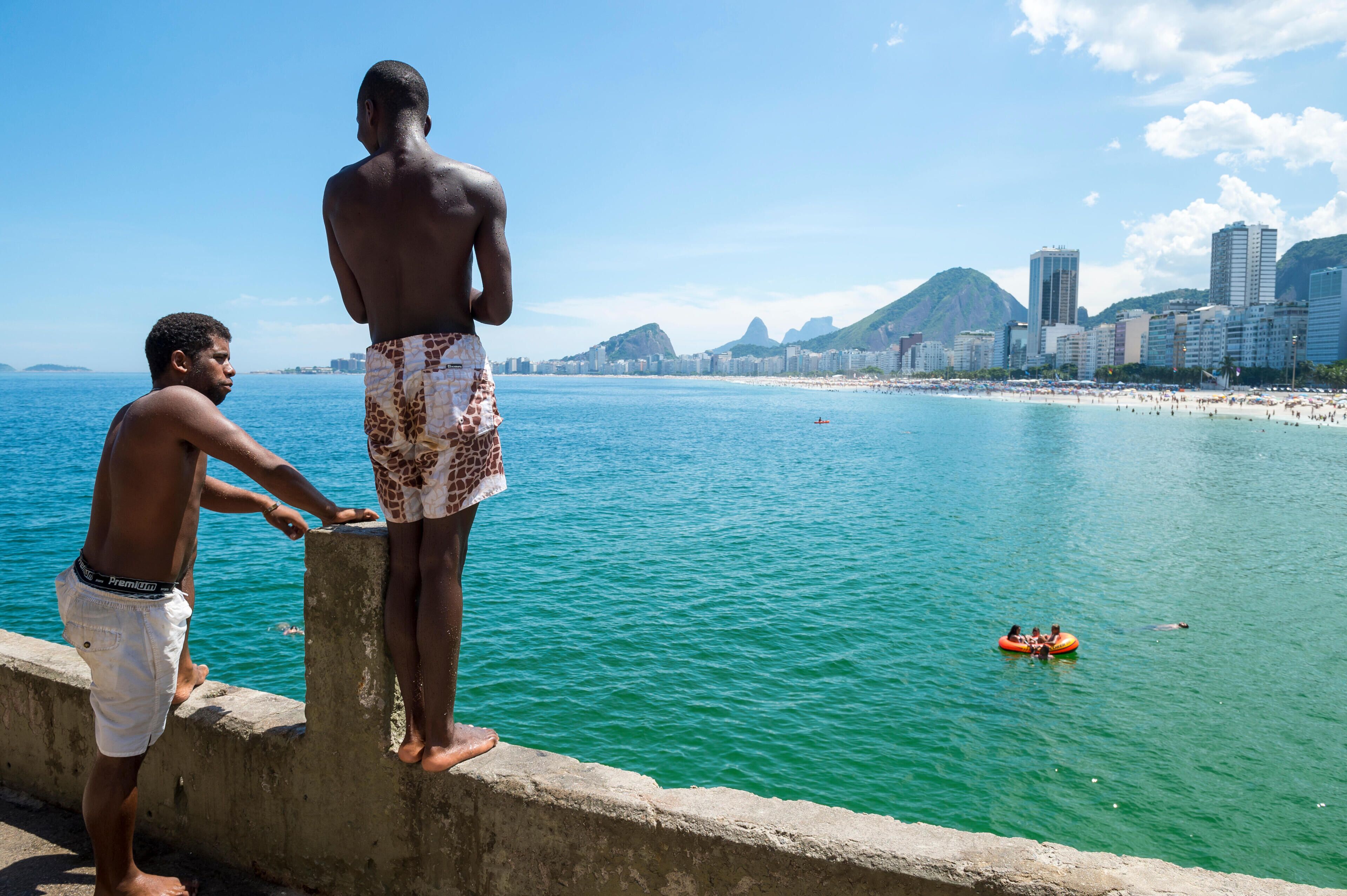 RIO DE JANEIRO - FEBRUARY 27, 2016: Young Brazilians gather to dive from the ledge at Leme, at the far end of Copacabana Beach.