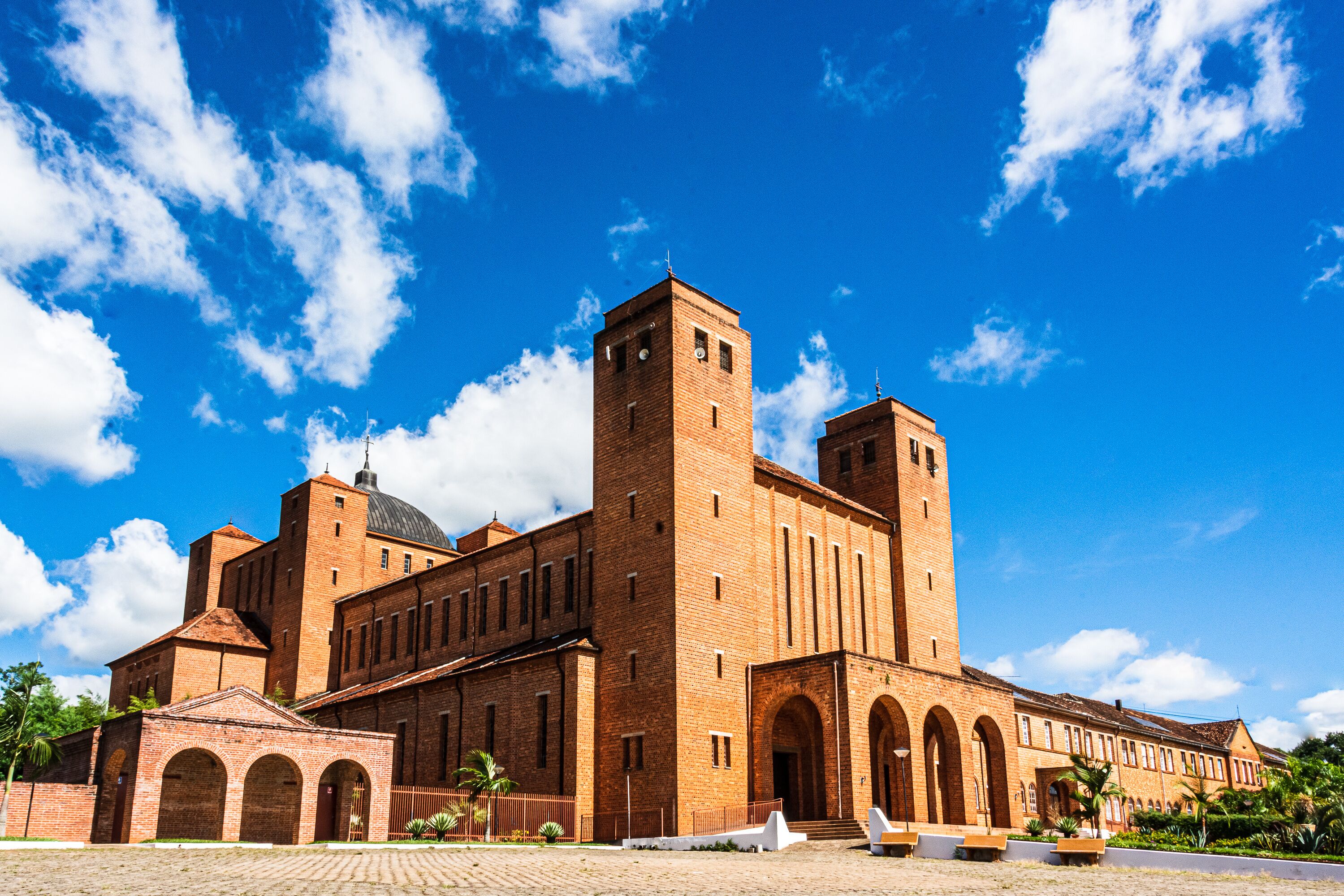 A large brick building with a central tower, arched windows, and a dome.