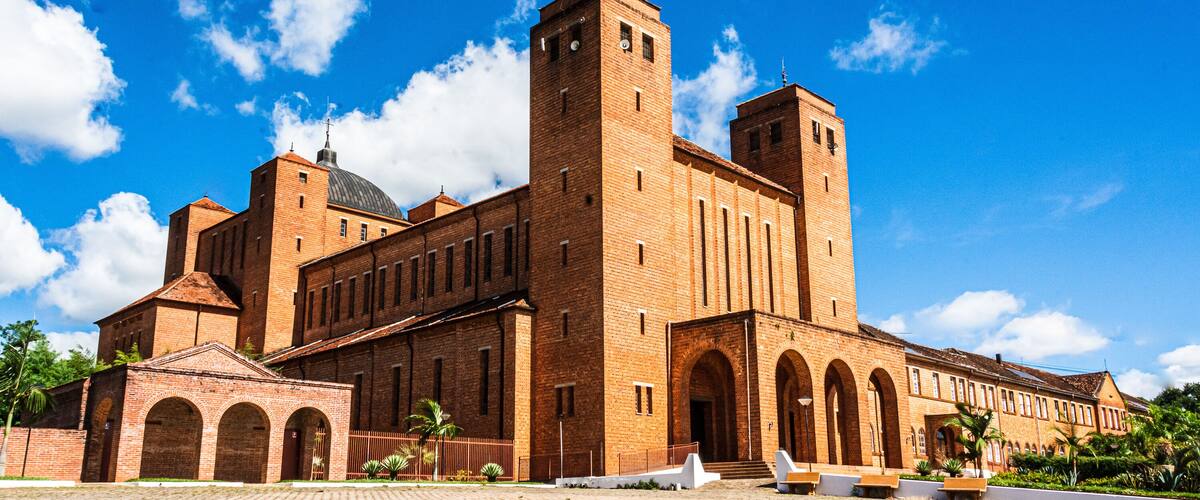 A large brick building with a central tower, arched windows, and a dome.