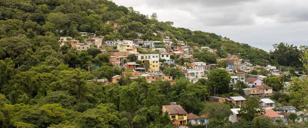 A hillside settlement with densely packed houses surrounded by lush greenery.