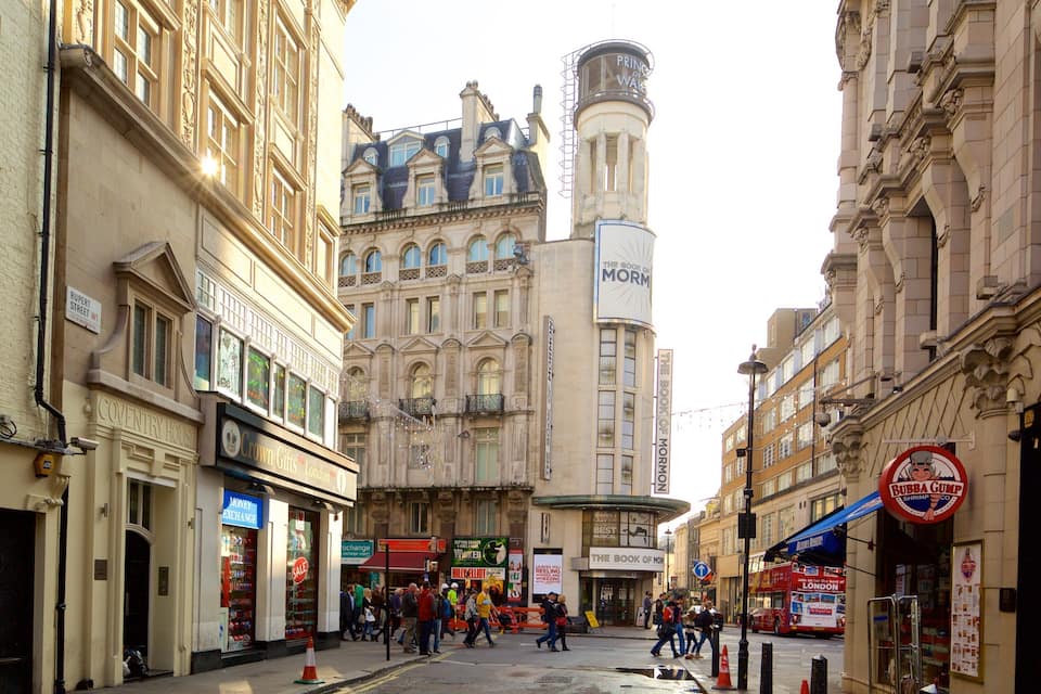 A busy street with historic buildings, including a prominent tower with a clock.