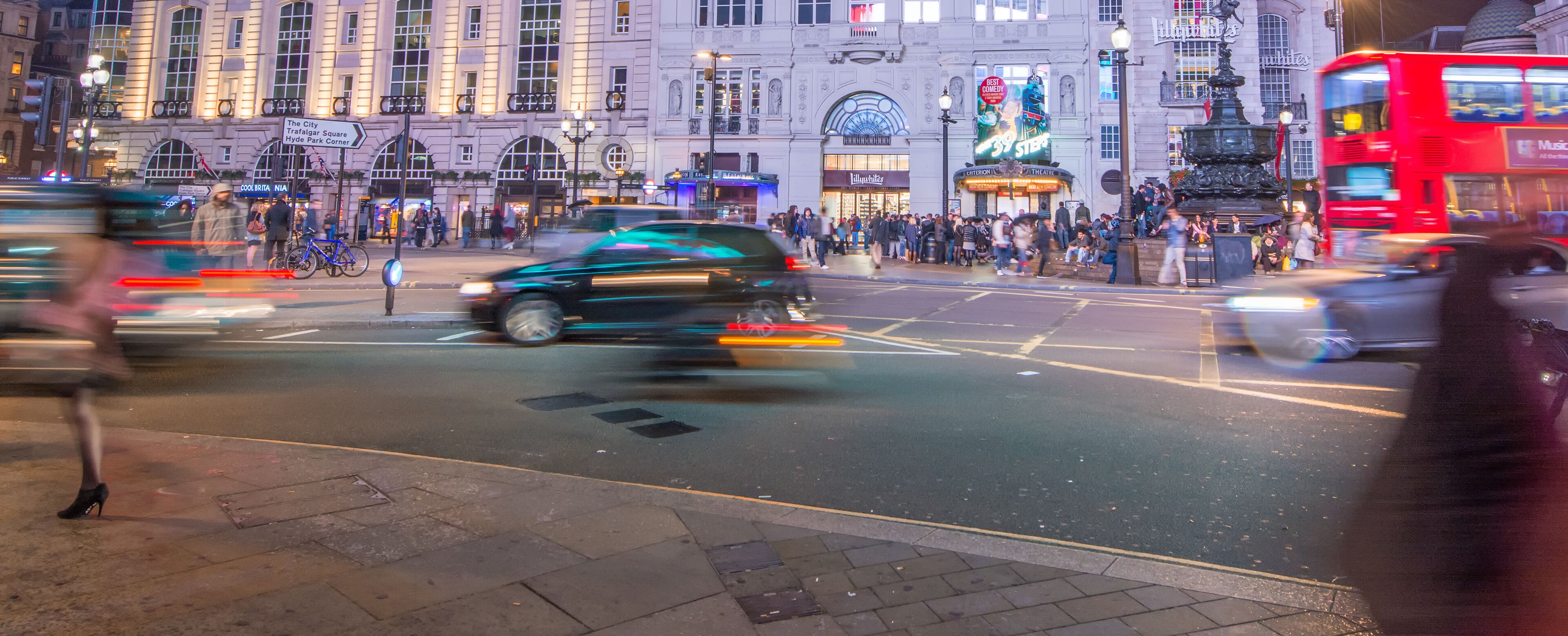 LONDON - SEPTEMBER 27 : Motion blurred traffic and people pass t