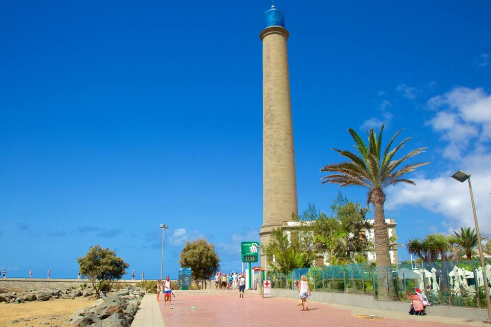 A tall tower, a beach, and palm trees.