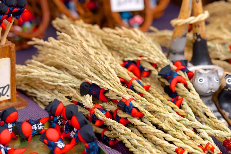 Esposizione di oggetti tradizionali giapponesi tra cui corde, bambole e un cartellino con il prezzo.